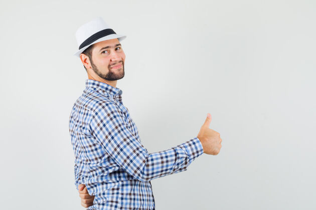 男性年轻人穿着格子衬衫 戴着帽子 竖起大拇指 看上去很高兴胡茬现代休闲