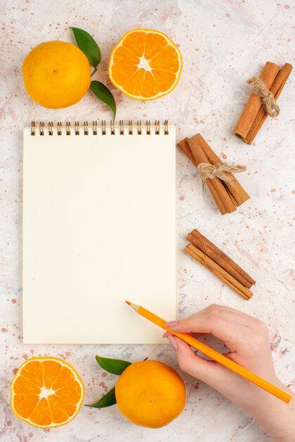 卷笔刀顶视图新鲜的柑桔肉桂棒笔记本铅笔在女人的手上明亮的孤立的表面肉桂明亮教育