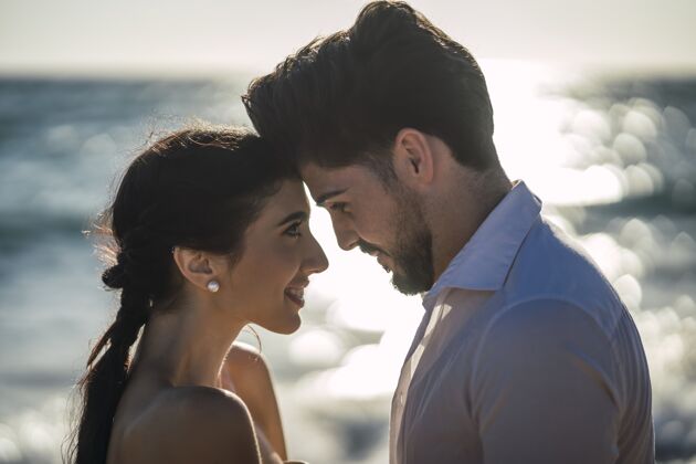 新郎一对穿着白色衣服的白种人情侣在沙滩上拥抱 拍摄婚礼照片浪漫自然浪漫