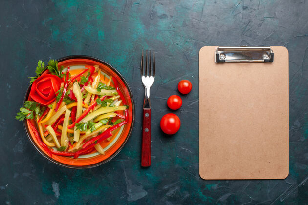 胡椒顶视图切碎的甜椒沙拉放在盘子里 黑色桌子上有记事本记事本胡椒有色的