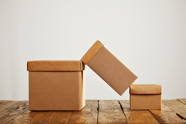 集装箱一个高高的纸板箱平衡在两个类似的箱子上面 在一个工作室里 箱子的盖子是白色的堆叠的装运的邮政