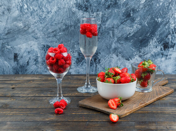 顶视图水晶杯里的覆盆子和碗里的草莓水晶健康叶子