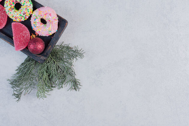 球美味的甜甜圈 黑色盘子上有洒水器和果酱粉色面包房圣诞节