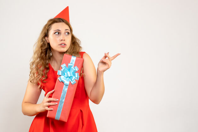 女性正面图身着红色连衣裙的年轻女性用礼物庆祝圣诞节情感派对年轻女性