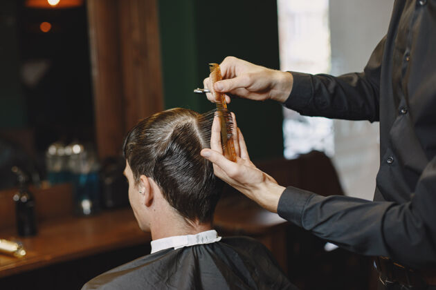 胡子男人和发型师一起工作理发师和客户一起工作年轻理发室内