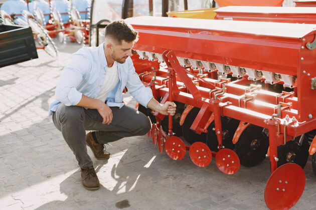 耕耘机农艺师选择一个新的播种机在商店的户外地面上的人农业机械商店车辆开放