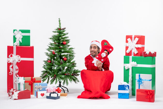 礼物圣诞老人带着礼物盒和圣诞树坐着圣诞庆祝快乐