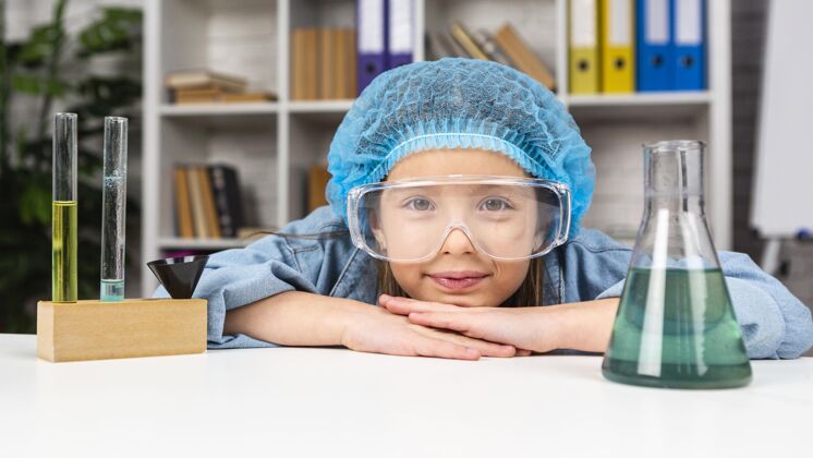 化学家戴着发网和安全眼镜的女孩用试管做科学实验科学家化学安全
