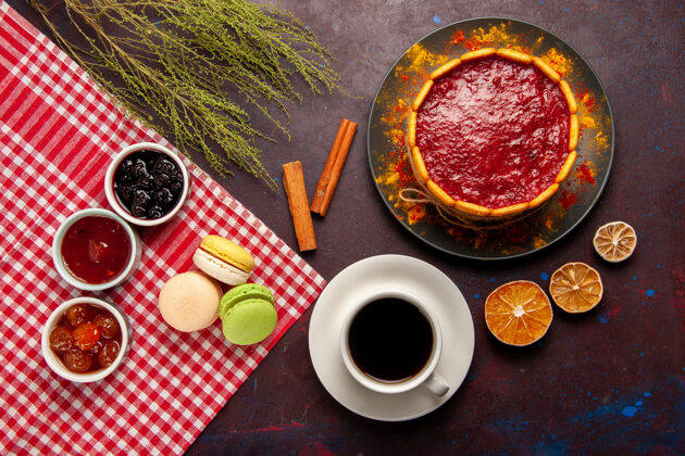 法式俯瞰美味的法式马卡龙配水果果酱和一杯咖啡放在深色桌子上甜甜的水果果酱蛋糕饼干甜甜的糖咖啡晚餐水果