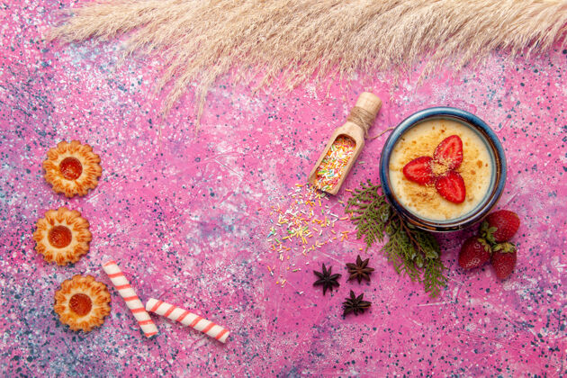 生的俯瞰美味的奶油甜点与红色切片草莓和饼干的浅粉色背景甜点冰淇淋浆果奶油甜水果冰淇淋奶油切片