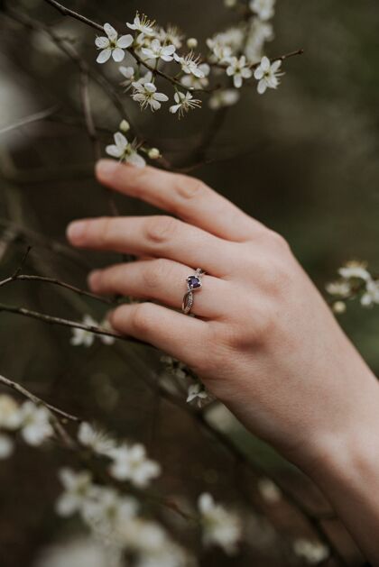 宝石美丽的银戒指与一个柔软的女性手紫色钻石戒指珠宝圆形