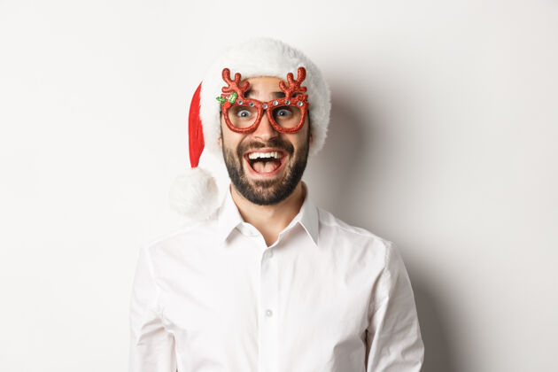 男人特写镜头中的兴奋的胡须男子在圣诞眼镜和圣诞帽看惊喜的促销优惠 寒假广告的概念圣诞老人成人幸福