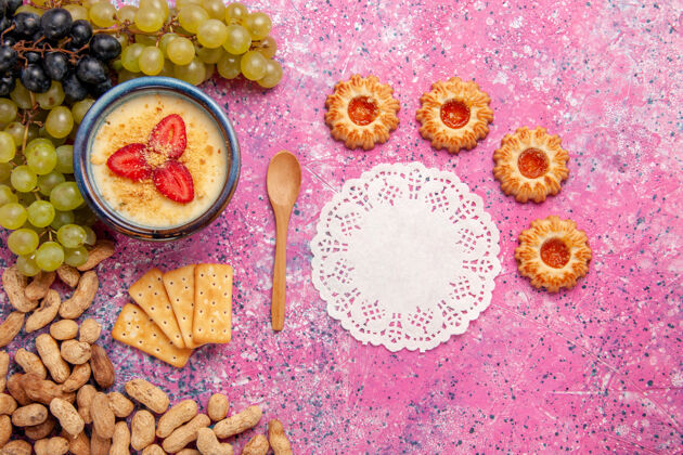 新鲜顶视图美味的奶油甜点与新鲜葡萄饼干和花生淡粉色背景甜点冰淇淋浆果奶油甜水果水果可食用水果膳食