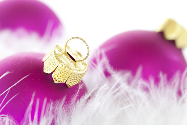 庆祝背景模糊的灯光下 紫色圣诞饰品和羽毛的特写镜头装饰季节装饰