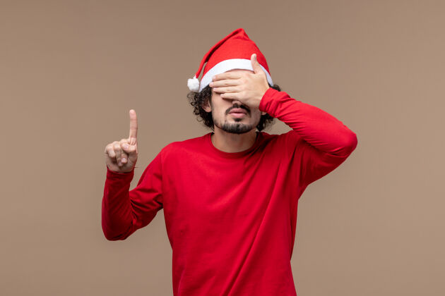 背景前视图红色的男性在棕色背景上遮住眼睛圣诞节表情服装成人