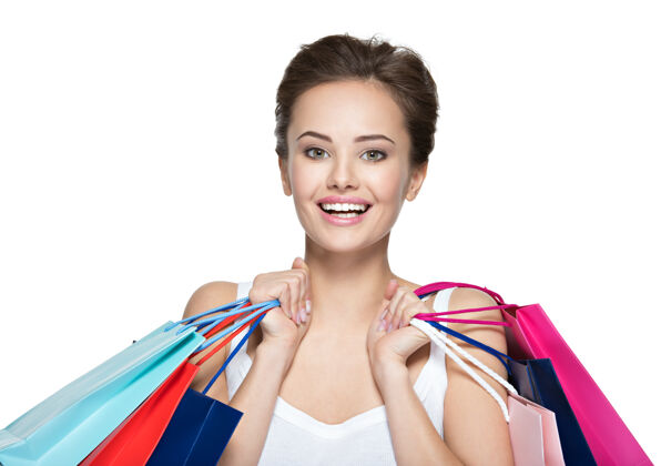 女士购物后带着购物袋的快乐的年轻微笑的女人买女买