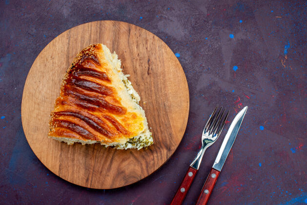 深色俯视图：在黑暗的书桌上 烤面点包和绿色的面包一起切成薄片绿色美味烘焙