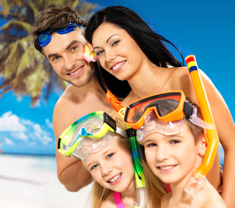 男性在热带海滩 一个快乐有趣的美丽家庭和两个孩子的肖像 带着保护性的游泳面罩儿童后代热带