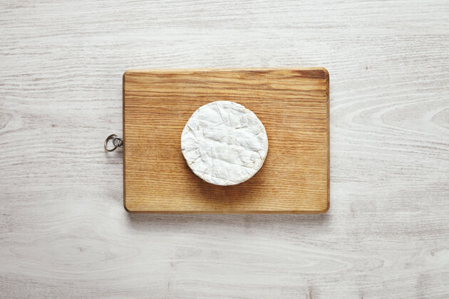 片俯视图上的乡村木板上的卡门伯特奶酪完美的圆形孤立的老白色木桌在中间配料木材膳食