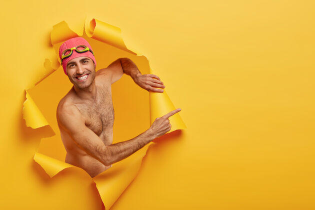 促销帅气开朗的男人在夏日重现 制作创意照片 在撕破的纸洞里摆姿势游泳高兴感觉