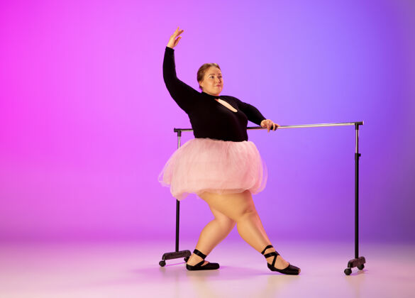 转移美丽的高加索人模特在霓虹灯下的渐变紫粉色工作室背景上练习芭蕾舞激励 包容 梦想和成就的理念值得成为芭蕾舞演员包容训练身体