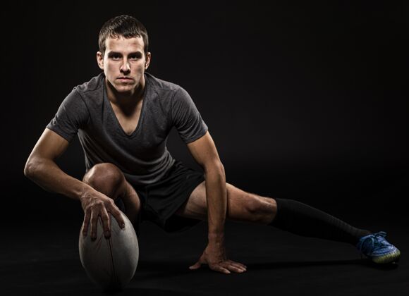 水平前视图的运动英俊的橄榄球运动员拿着复制空间球比赛竞技运动