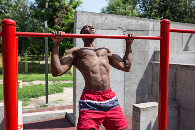 非洲健身运动员在体育场做运动非裔或非裔美国男子在城市户外拉起体育锻炼健身 健康 生活方式的概念热身运动员训练