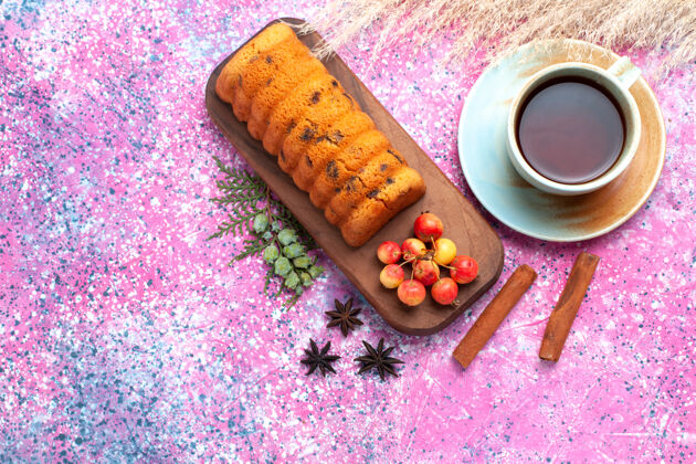 派俯瞰美味的蛋糕 甜甜可口 樱桃 肉桂和一杯茶放在粉红色的桌子上肉桂杯子茶