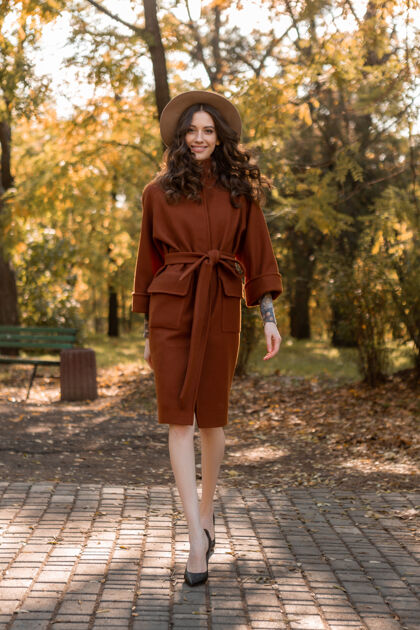 连衣裙迷人时尚微笑的瘦身女子卷发漫步公园身着暖棕色外套 秋日时尚街头风时尚优雅女士