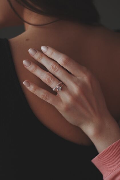 钻石特写镜头中一只女性手上戴着一枚漂亮的钻戒在另一位女性的背上奢侈品新郎珠宝