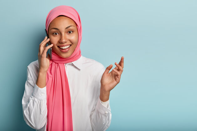 正面开朗的阿拉伯女性有电话交谈 用手做手势 积极解释事情积极乐观高兴