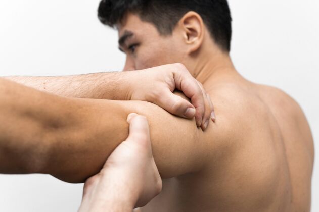 移动从理疗师那里得到肩膀疼痛按摩的男人补救水平运动