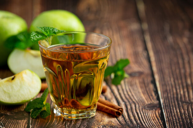 黄瓜一杯青苹果保健茶放在新鲜青苹果旁边水果苹果草药