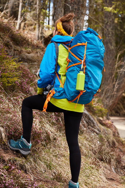 女士图为活跃的女游客登山 背着大背包 穿着靴子背包岩石夹克