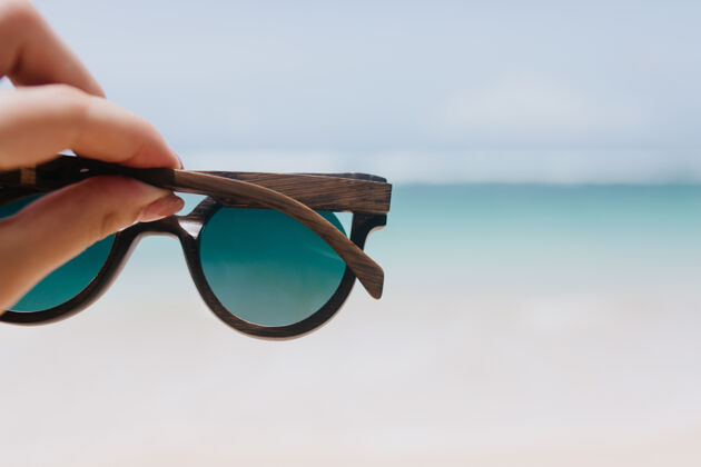 度假海洋的户外照片 女性的手放在前景上在海上戴着夏季太阳镜的女人夏天女人度假
