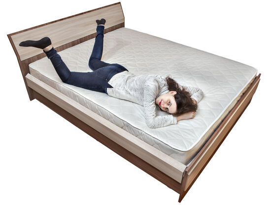 女人一个年轻的白人女孩正在床上休息 床垫是白色背景的木制床架床年轻人人