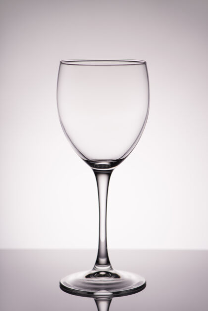 吐司垂直全尺寸照片 干净透明 带眩光 酒杯隔离在灰白色墙壁上 有梯度水晶干杯轮廓