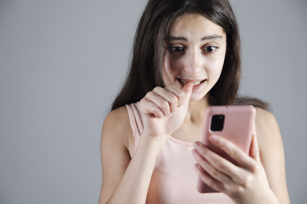 手机拿着粉色智能手机的年轻女子吓坏了年轻电话女性