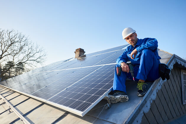 生态电工在现代住宅的屋顶上安装太阳能板工人发电技术人员