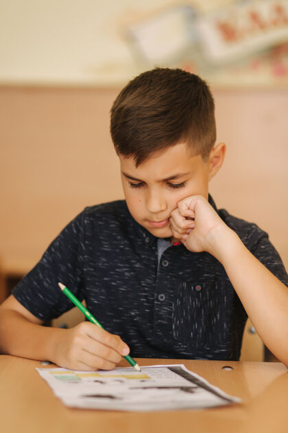 教育全神贯注的小学生坐在课桌旁 在练习本上写字学习理念小学年轻学校