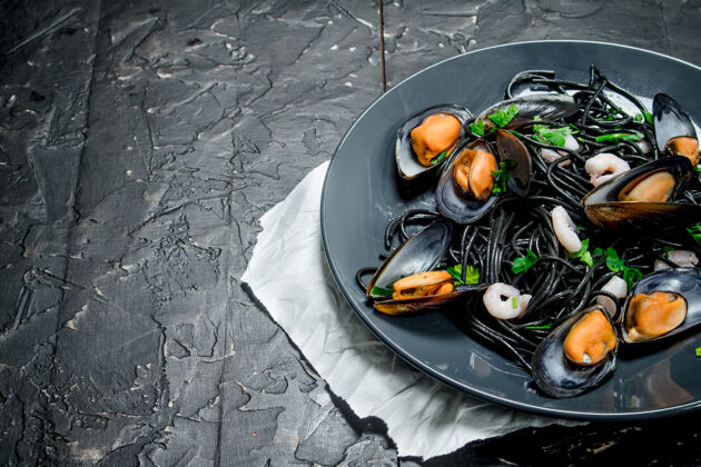 软体动物地中海食物乡村桌上的墨鱼墨汁蛤蜊意大利面沙司一餐大蒜
