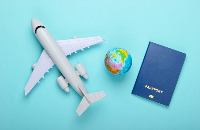 计划旅游和旅游概念地球仪 护照 蓝色粉彩墙上的客机雕像顶视图平躺旅行平面时尚