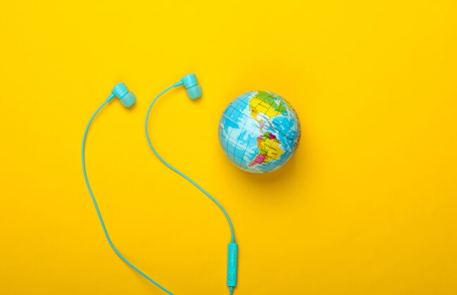 通信世界之歌全球音乐排行榜地球的音乐立体声耳机和黄色墙上的地球仪顶视图媒体耳机耳机