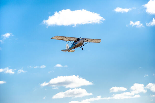 光一架小型单引擎飞机在蓝天上空飞行头顶发动机现代