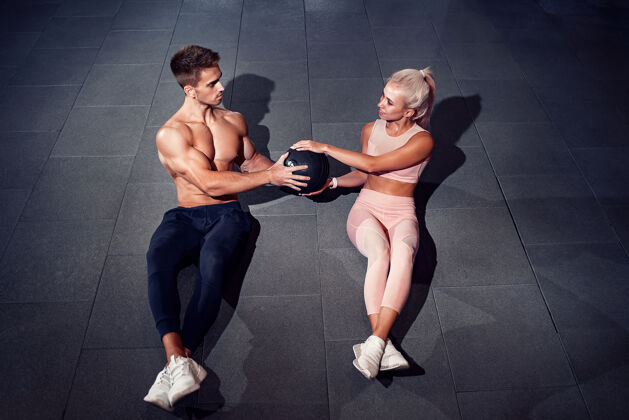 运动装健身夫妇在健身房做腹球运动球健身室健身球