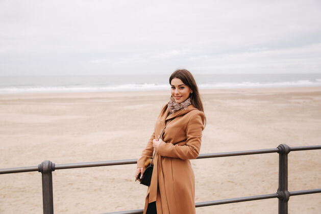 女人一位穿着漂亮外套化妆的时髦女士站在北海沿岸女人微笑年轻一外套