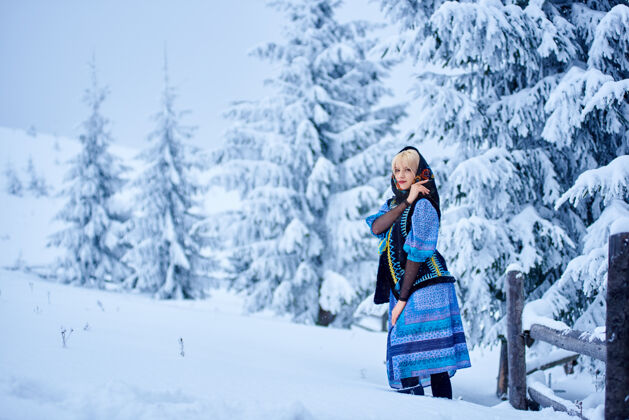 金发雪景背景上的冬日女人肖像服装乌克兰刺绣