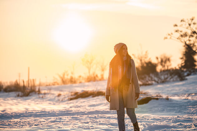 时尚夕阳时分 冬日乡间 一身暖洋洋的快乐少女 在新鲜的白雪上漫步全身欢呼远眺
