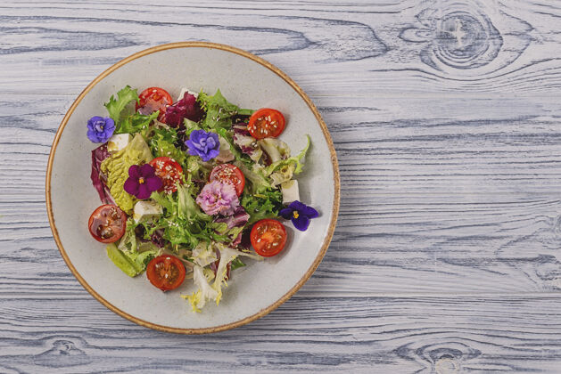 健康蔬菜沙拉 番茄 莴苣和奶酪点缀着可食用的花春季食品概念背景和拷贝空间光食用花有机