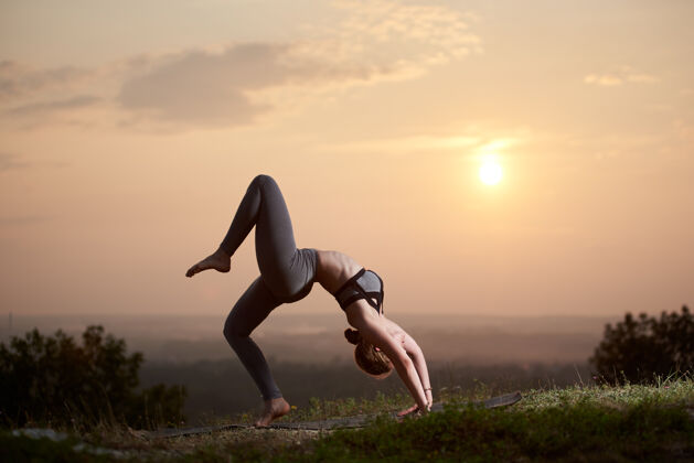 户外日落时分在户外练瑜伽的年轻女子日落控制锻炼
